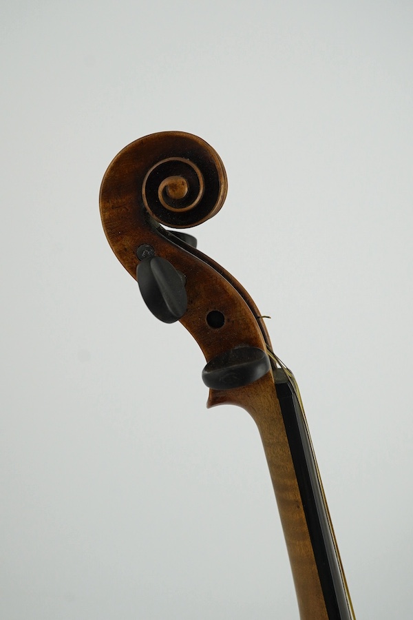 A late 19th century German Nuremberg school violin c.1880, Stradivarius pattern with a finely carved scroll and a large 14.25 inch body, together with a fully mounted German octagonal bow, contained within a contemporary